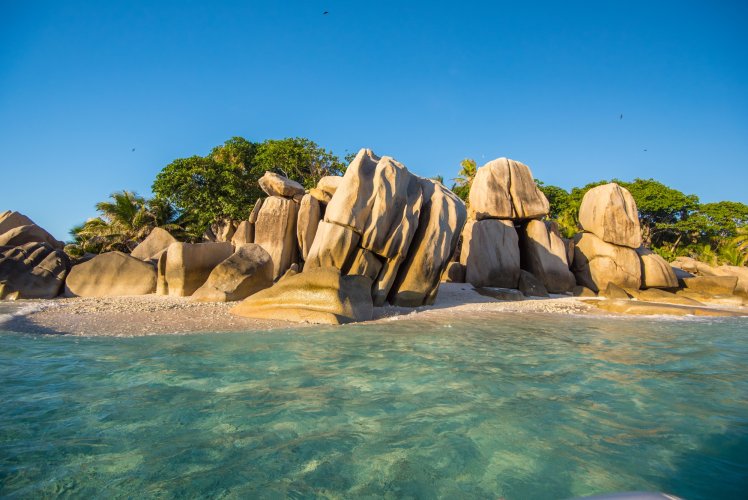 Rochers de granit et plage aux Seychelles vus depuis la mer