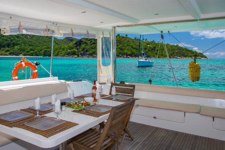 Table dressée sur le pont arrière d'un catamaran au mouillage aux Seychelles