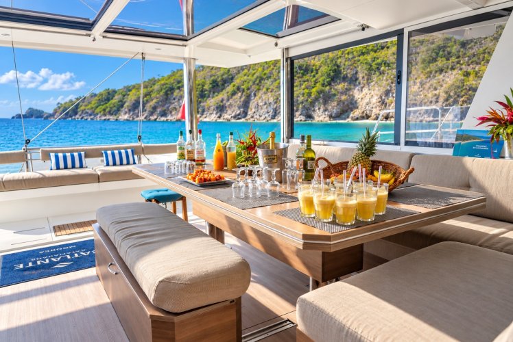 Apéritif servi sur la table du cockpit d'un catamaran Catlante, face à la mer